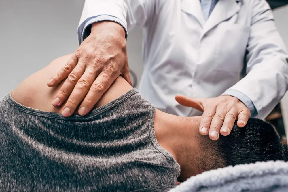 Chiropractor adjusting a patient's neck and shoulder